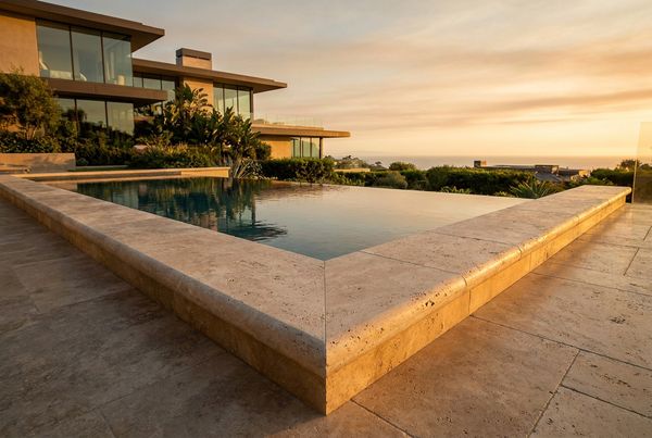 Travertine pool coping styled with a light deck