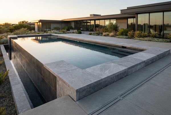 Swimming pool coping styled on a raised retaining wall