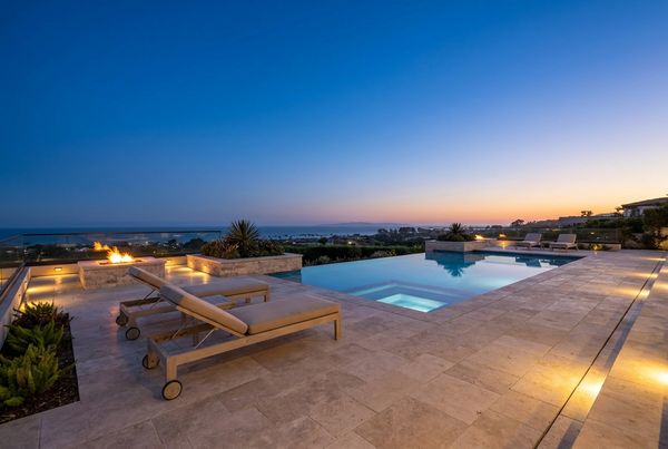Ivory travertine pool deck glowing at dusk