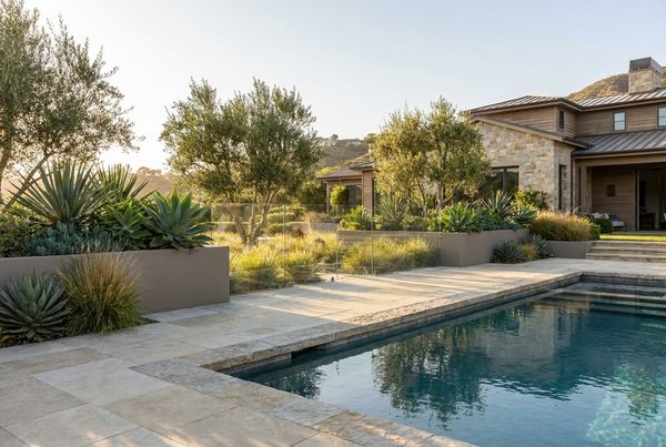 Pool fence softened with layered planting and ornamental grasses
