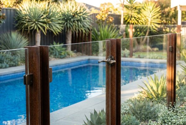 Modern black metal pool fence against clean concrete decking