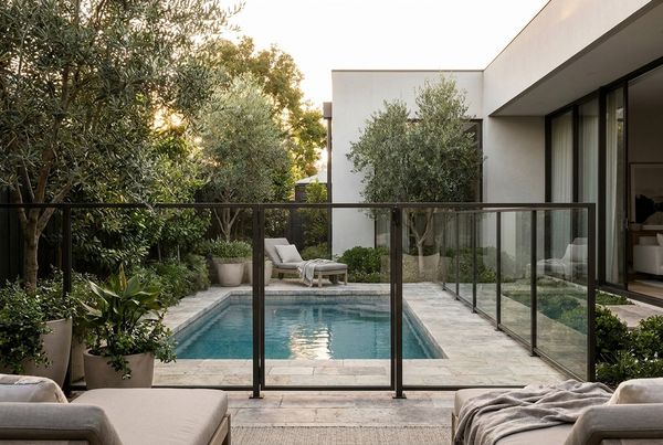 Pool fence softened with layered planting and ornamental grasses