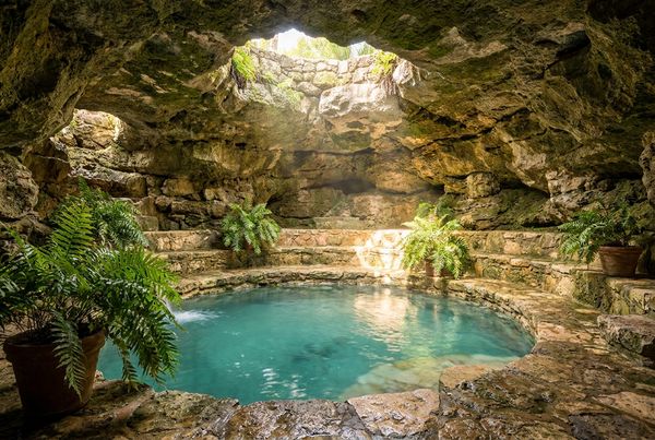Close-up of a natural rock pool grotto cave over blue water
