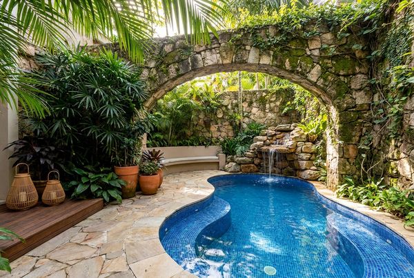 Pool grotto with a stone bridge crossing over the water