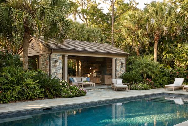 Pool house glowing softly with warm light at dusk