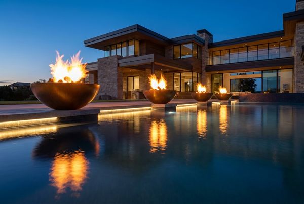 Fire bowls reflecting on the water at night