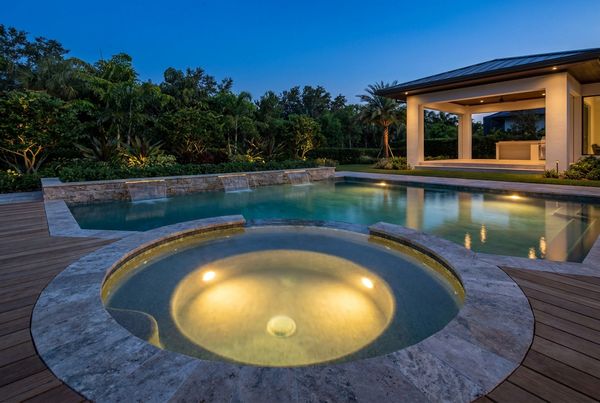 Illuminated spa spillover glowing into the pool