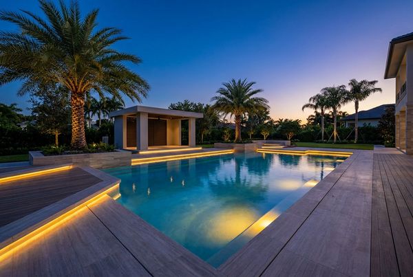 Warm landscape lighting washing a poolside deck at night