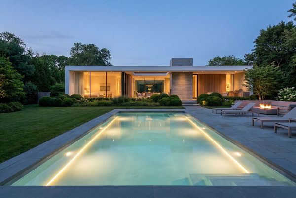 Contemporary pool with warm perimeter lighting at night