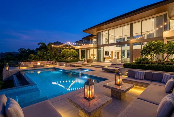 Evening pool party glowing with string lights and colorful pool lighting