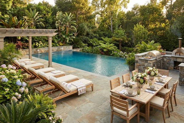 Decorated party table set beside a backyard pool