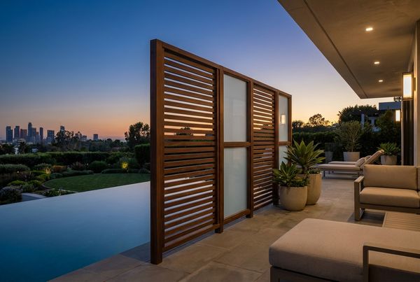 Privacy screen beside a pool glowing at dusk