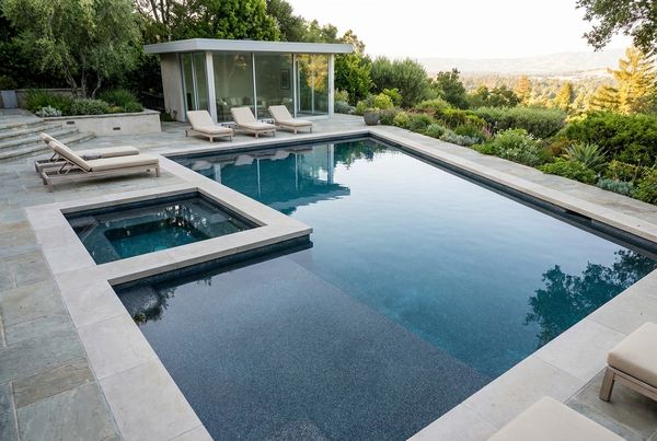Resurfaced pool with a fresh dark pebble interior finish and blue water