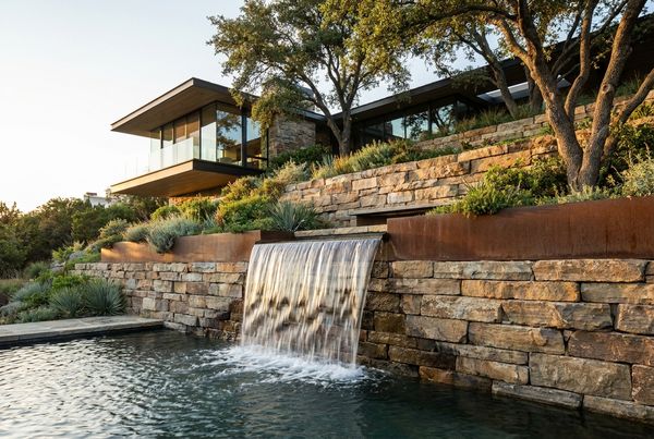 Retaining wall with a waterfall spilling into a swimming pool