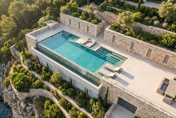Modern smooth concrete retaining wall beside a pool
