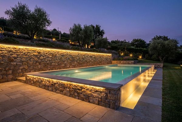 Boulder retaining wall creating a naturalistic pool surround