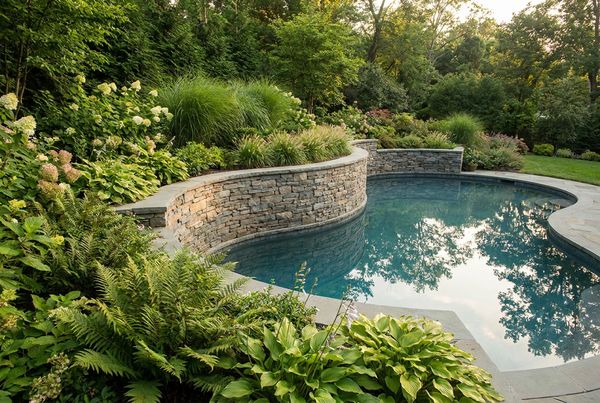 Raised spa built into a poolside retaining wall