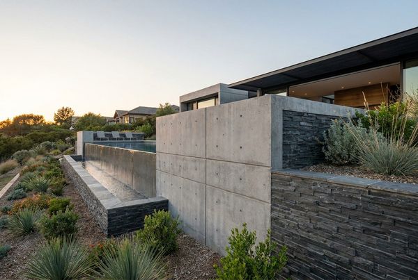 Retaining wall with built-in planters spilling greenery over a pool