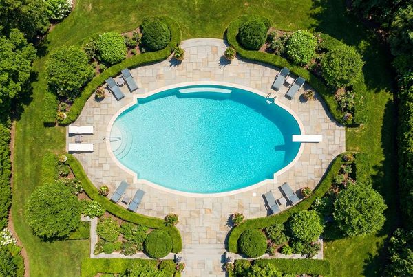 Aerial view of an oval pool with a simple curved deck