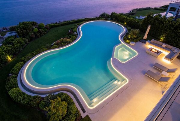 Aerial view of an L-shaped pool wrapping a patio corner