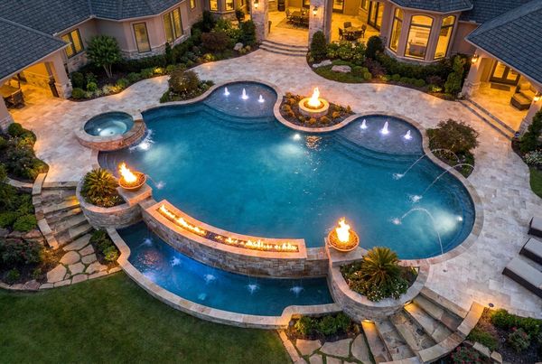Aerial view of a curved freeform pool with a beach entry