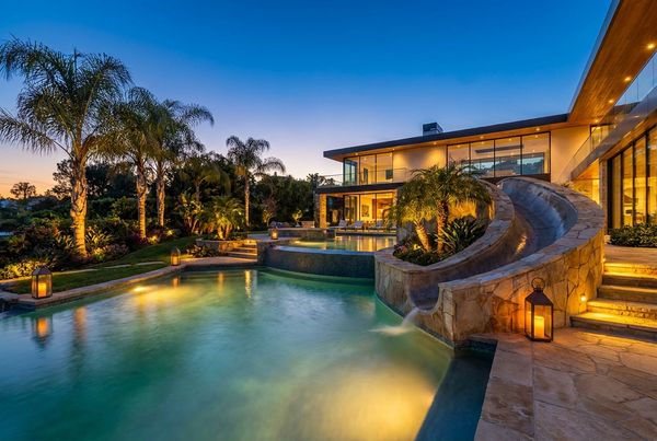 Rock waterfall slide built into boulders spilling into a lagoon pool