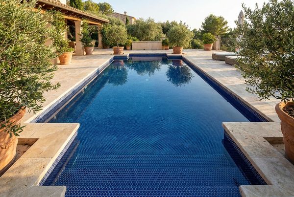 Blue penny-round mosaic tile lining a pool wall