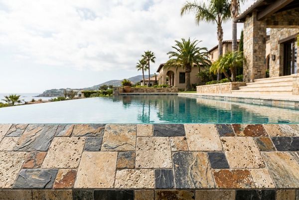 Natural stone waterline tile on a resort-style pool