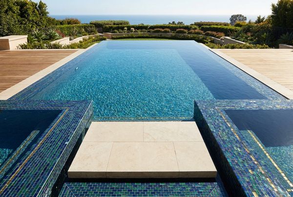 Natural stone waterline tile on a resort-style pool