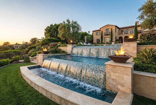 Scupper spouts pouring from a raised pool wall