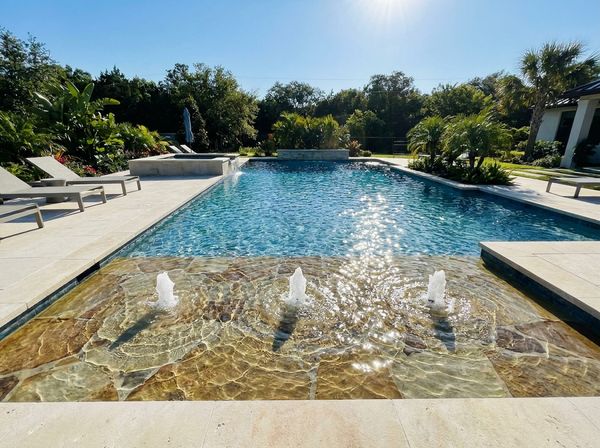 Pool waterfall feature in a landscaped backyard