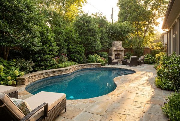 Saltwater pool at dusk with warm deck lighting and a spillover spa