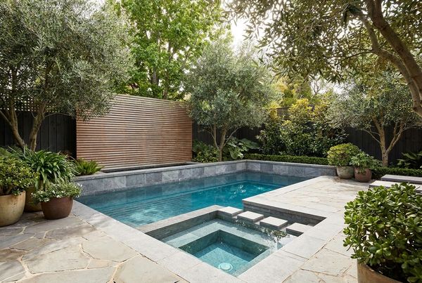 Small L-shaped pool tucked into a backyard corner