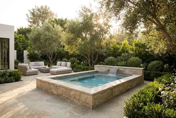 Compact spool pool with spa jets in a small backyard