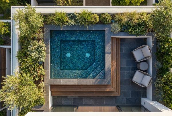 Spool pool with dark tile interior reflecting the sky