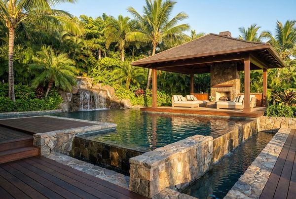 Tropical pool with a natural rock waterfall cascading into the water