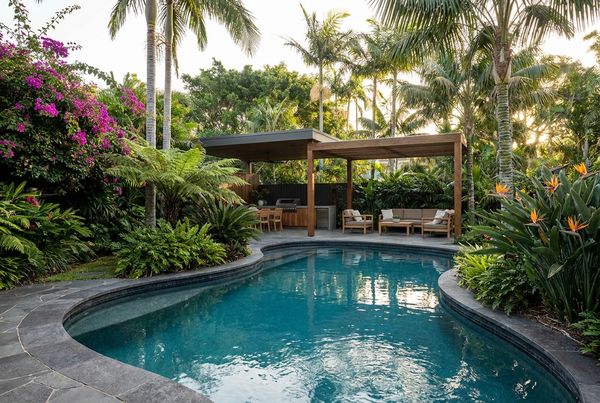 Tropical pool lit warmly at dusk with glowing water
