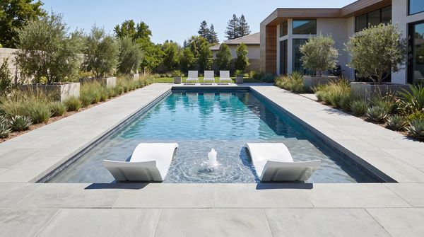 Modern rectangular pool with tanning ledge, in-water loungers and bubbler