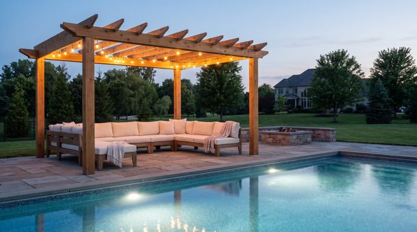 Poolside lounge under a cedar pergola with string lights at dusk